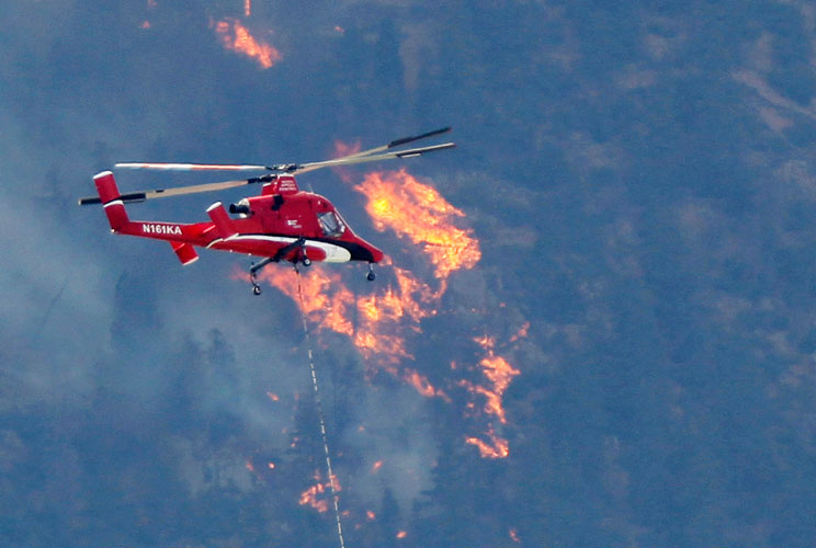 A firefighting helicopter approaches the Waldo Canyon fire west of Colorado Springs in Colorado, June 26, 2012. A monster Colorado wildfire raging near some of the most visited tourist areas in the state took a turn for the worse last Tuesday as hot winds