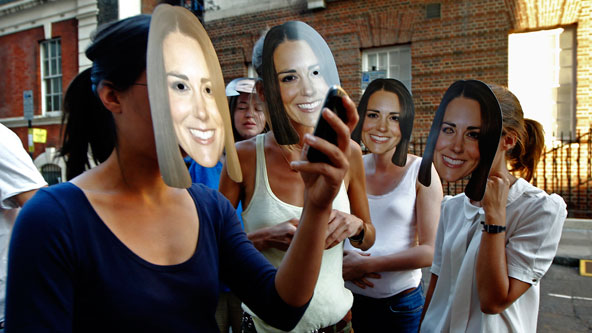 		<p>Women wear masks bearing Kate's face outside the Lindo Wing of St Mary's Hospital, where Kate would deliver the baby.</p>