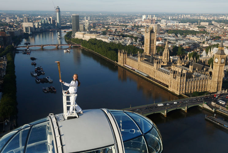 Torch bearer Amelia Hempleman-Adams, age 17, stands on top of a capsule on the London Eye as part of the torch relay ahead of the London 2012 Olympic Games in London July 22, 2012.  REUTERS/Luke MacGregor  (BRITAIN - Tags: SPORT OLYMPICS TPX IMAGES OF THE