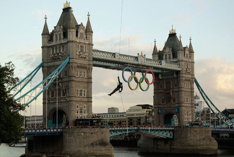 A British Royal Marine abseils from a helicopter with the Olympic Flame into the grounds of the Tower of London during Day 63 of the Torch Relay in central London July 20, 2012. The London 2012 Olympic Games will start in a week's time. REUTERS/Pool/ (BRI