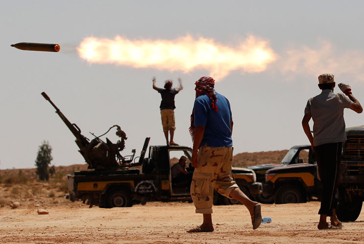 Anti-Gaddafi fighters fire a multiple rocket launcher near Sirte, one of Muammar Gaddafi's last remaining strongholds, September 24, 2011. Libyan provisional government forces backed by NATO warplanes swarmed into the city of Sirte on Saturday but weather