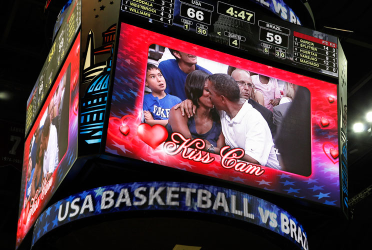 U.S. President Barack Obama and first lady Michelle Obama are shown kissing on the "Kiss Cam" screen during a timeout in the Olympic basketball exhibition game between the U.S. and Brazil national men's teams in Washington, July 16, 2012.     