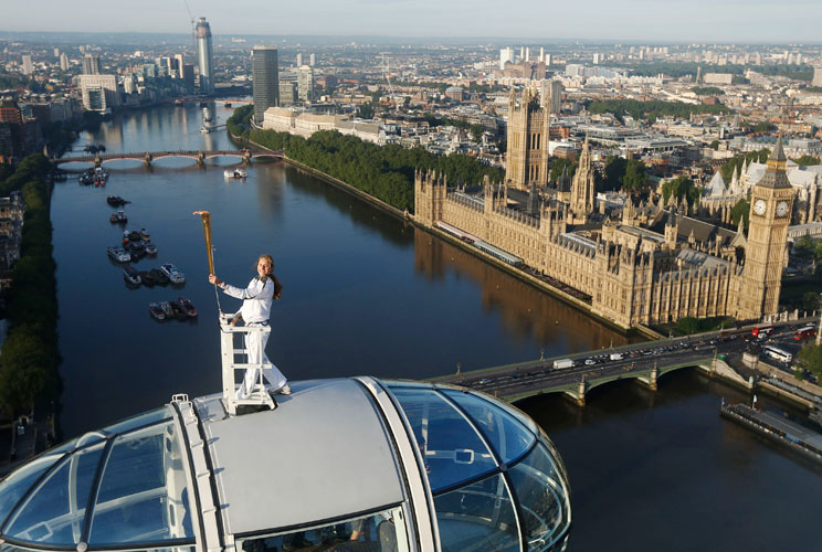 Torch bearer Amelia Hempleman-Adams, age 17, stands on top of a capsule on the London Eye as part of the torch relay ahead of the London 2012 Olympic Games in London July 22, 2012.  