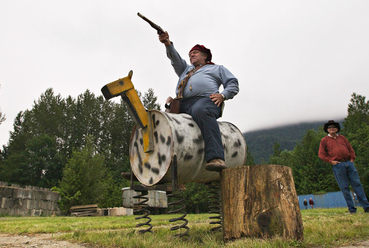 Roland Fielder sits on a barrel made to look like a horse while firing a flintlock pistol during the 40th Annual Buffalo Shoot in Chilliwack, British Columbia July 22, 2012. Dressed in period clothing participants take part in festivities from rifle and p