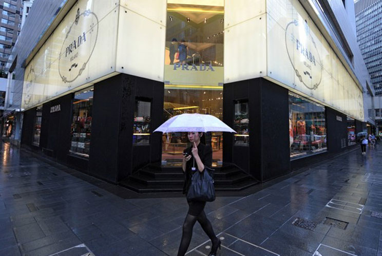 A woman walks past a Prada shop on a rainy afternoon in Hong Kong. China's wealthiest are getting richer, with the minimum amount needed to make the top 400 rising to $425 million (U.S.) from $300 million in 2010.