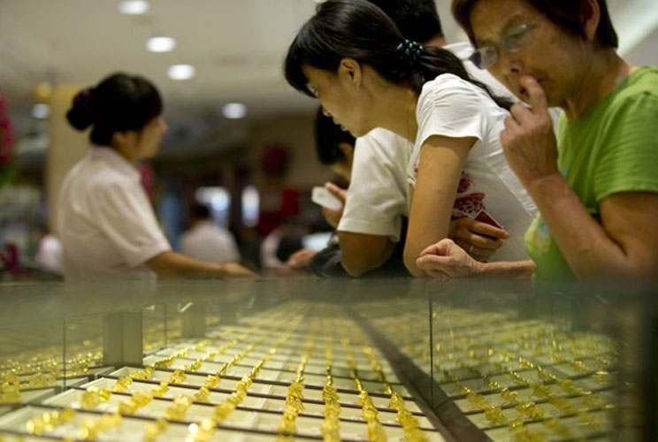 People shop for gold at Beijing Caibai precious metals and jewelry store.