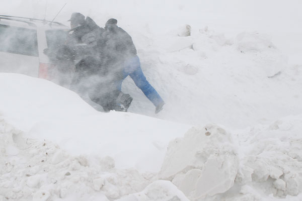 Men push a stalled car on the road in heavy snowfall near Glodeanu Silistea village, 75 km (47 miles) northeast of Bucharest February 12, 2012, as icy weather continues across Europe. Romania's counties of Buzau, Galati, and Vrancea have been hit by heavy