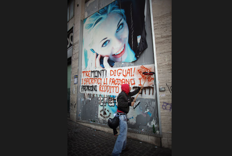 A protester pastes a political message to a billboard as he takes part in a protest against austerity cuts and lack of jobs on November 17, 2011 in Naples, Italy. Thousands of students took to the streets of Naples to protest against the lack of opportuni