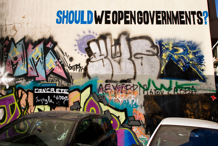 Cars are parked in front of graffiti displayed on a building on December 6, 2011 in Athens, Greece. Graffiti artists throughout the city are expressing the effects of austerity measures that have plagued the community as Greece continues to struggle in de