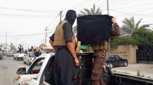 Fighters of the Islamic State of Iraq and the Levant (ISIL) celebrate on vehicles taken from Iraqi security forces, at a street in city of Mosul