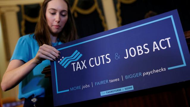 A congressional aide places a placard on a podium for the House Republican's legislation to overhaul the tax code on Capitol Hill in Washington
