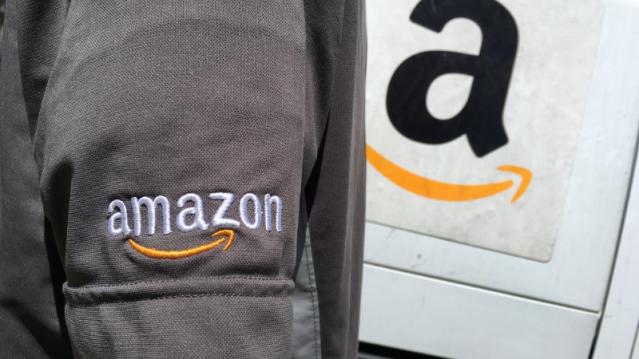 An Amazon.com Inc driver stands next to an Amazon delivery truck in Los Angeles, California, U.S., May 21, 2016. REUTERS/Lucy Nicholson