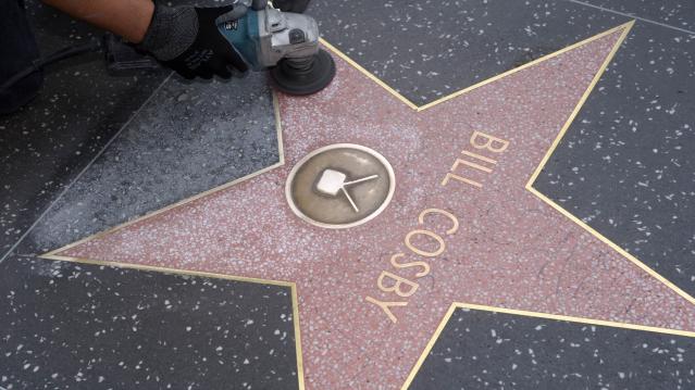 A worker cleans graffiti on actor Bill Cosby's star on the Hollywood Walk of Fame in Los Angeles December 5, 2014. REUTERS/Phil McCarten