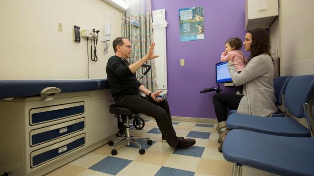 Dr. Benjamin Hoffman (L) speaks with Nancy Minoui about 9 month old Marion Burgess, who suffers from a chronic heart condition, at an appointment at the Dornbecher Children's hospital in Portland, Oregon, U.S. December 6, 2017. Picture taken December 6, Dr. Benjamin Hoffman speaks with Nancy Minoui about 9 month old Marion Burgess, who suffers from a chronic heart condition, at an appointment at the Dornbecher Children's hospital in Portland