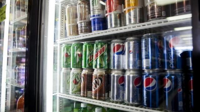 Cans of soda are displayed in a case at Kwik Stops Liquor in San Diego, California February 13, 2014. REUTERS/Sam Hodgson/Files