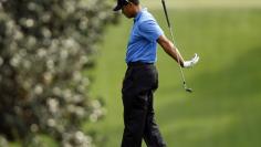 Woods reacts after hitting his approach shot to the 18th green into a sand trap during the 2009 Masters golf tournament at the Augusta National Golf Club