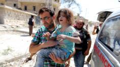 A man carries a girl that survived double airstrikes on the rebel held Bab al-Nairab neighborhood of Aleppo