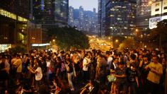 Protesters stand on a bridge as they block the main street to the financial Central district outside of the government headquarters building in Hong Kong