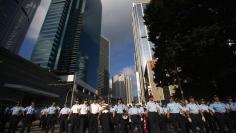 Police officers stand as protesters try to block a street to the financial Central district, near the government headquarters in Hong Kong