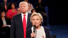 Republican U.S. presidential nominee Trump listens as Democratic nominee Clinton answers a question from the audience during their presidential town hall debate in St. Louis