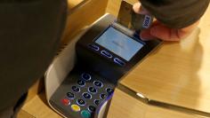 A customer pays with a credit card at a store in Paris