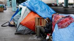 A homeless man, takes shelter under a freeway during an El Nino driven storm in San Francisco, California