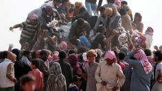 Iraqi refugees that fled violence in Mosul and internally displaced Syrians who fled Islamic State controlled areas in Deir al-Zor, gather near the Iraqi border