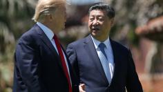 U.S. President Donald Trump and China's President Xi Jinping chat as they walk along the front patio of the Mar-a-Lago estate after a bilateral meeting in Palm Beach