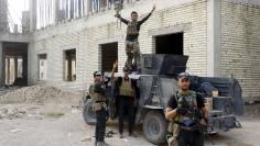 Iraqi security forces celebrate after clashes with Islamic State militants, at the University of Anbar, in Anbar province