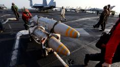 An aviation ordnanceman transports bombs onboard the USS Dwight D. Eisenhower CVN 69 carrier in Arabia Gulf