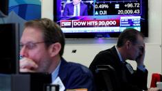 Traders work on the floor of the NYSE as the Dow Jones Industrial Average passes the 20,000 mark in New York