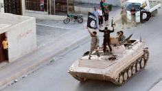 Militant Islamist fighters take part in a military parade along the streets of northern Raqqa province