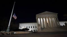 Capitol Hill police officers lower the U.S. flag at the Supreme Court in Washington D.C. after the death of U.S. Supreme Court Justice Antonin Scalia