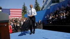 Obama takes off his coat after his remarks on trade at Nike corporate headquarters in Beaverton, Oregon