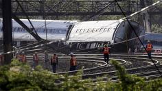 Officials survey the site of a derailed Amtrak train in Philadelphia, Pennsylvania 
