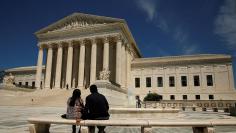 A couple sit in front of the Supreme Court  in Washington