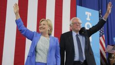Democratic U.S. presidential candidates Clinton and Sanders stand together during campaign rally in Portsmouth, New Hampshire