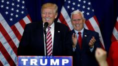 Republican presidential candidate Donald Trump (L) speaks as vice presidential candidiate Mike Pence claps at a post Republican Convention campaign event in Cleveland