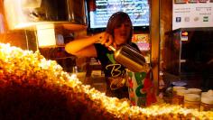 Cailynn Williams, 17, fills a bag of popcorn for a customer at the New Strand Theater in West Liberty