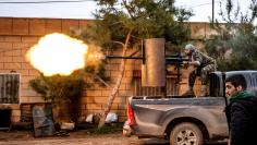 A fighter of YPG fires anti-aircraft weapon from Tel Tawil village in direction of Islamic State fighters positioned in countryside of town of Tel Tamr