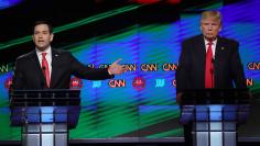Republican U.S. presidential candidate Rubio speaks as rival Trump listens during a debate in Miami