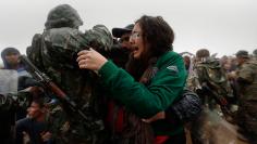 A Syrian refugee girl tries to escape from an armed Macedonian policeman at the Greek-Macedonian border