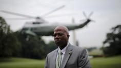 A member of U.S. Secret Service stands guard as Marine One helicopter with President Obama on board lifts off from the South Lawn of the White House in Washington for a day trip to Pittsburgh, Pennsylvania and New York