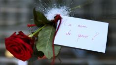 A rose placed in a bullet hole in a restaurant window the day after a series of deadly attacks in Paris