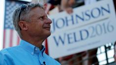 Libertarian presidential candidate Johnson listens as his running mate vice presidential candidate Weld speaks at a campaign rally in Boston