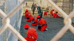 DETAINEES AT CAMP X RAY ARE WATCHED BY US MILITARY POLICE.