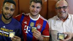 Sadler, Sharlatos, and Norman, who helped to disarm an attacker on a train from Amsterdam to France, pose with their medals at a restaurant in Arras, France