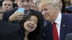 U.S. Republican presidential candidate Donald Trump poses for a selfie with an audience member at a campaign rally in Waterville Valley