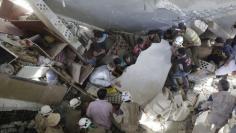 Civil defence members and civilians search for survivors under the rubble of a site hit by what activists said were cluster bombs dropped by Russian air force in Maasran town, south of Idlib, Syria