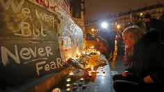 Flowers and candles are placed near the scene of a shooting the day after a series of deadly attacks in Paris